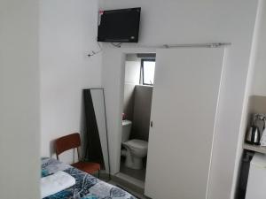 a bathroom with a toilet and a tv on the wall at 36 the trout lodge in Goodwood