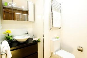 a white bathroom with a sink and a toilet at Spacious & Central Apartament in Santiago de Compostela