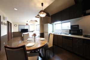 a kitchen with a wooden table and a dining room at KEI VILLA Tsujido in Takata