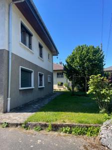 a house with a grass yard next to a building at Cocon de douceur in La Ravoire