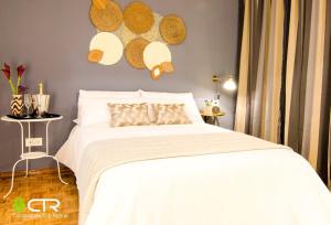 a bedroom with a bed with white sheets and hats on the wall at Spacious & Central Apartament in Santiago de Compostela