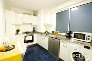 a kitchen with white cabinets and a microwave at Spacious & Central Apartament in Santiago de Compostela +10 photos