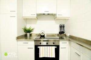 a kitchen with white cabinets and a stove top oven at Spacious & Central Apartament in Santiago de Compostela