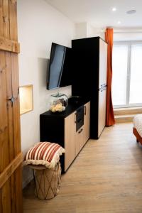 a kitchen with a black refrigerator and a tv at L'Escapade Etoilée Rosheim in Rosheim