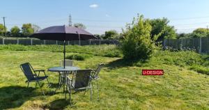 a table and chairs under an umbrella in a yard at The Green Yard - Ebike Available for Guests in Sundon