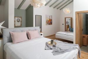 a bedroom with a large white bed with pink pillows at Luxury Villa Andrea Vrzika in forest near the sea with heated pool in Zagvozd +53 photos