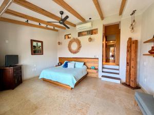 a bedroom with a bed and a flat screen tv at Villas Mimosa at La Ropa Beach in Zihuatanejo +54 photos
