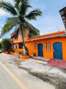 an orange house with a palm tree in front of it at Casa De Playa in Agua de Correa