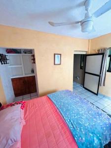 a bedroom with a bed with a pink and blue blanket at Casa De Playa in Agua de Correa