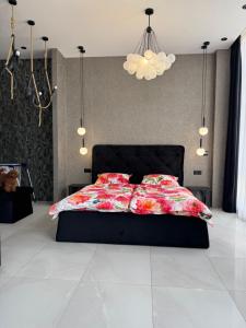 a bedroom with a black bed with a colorful comforter at Delmar Apartment Center in Dnipro