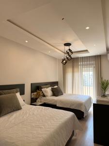 a bedroom with two beds and a chandelier at Swiss Apartments 3 in Velika Plaža +17 photos
