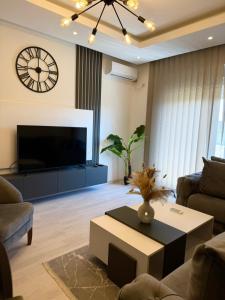 a living room with a large television and a coffee table at Swiss Apartments 3 in Velika Plaža