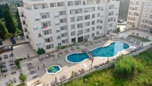 a large building with a swimming pool in front of it at Swiss Apartments 3 in Velika Plaža