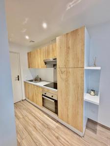 a kitchen with wooden cabinets and a refrigerator at Cozy studio Annecy in Poisy