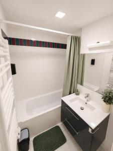 a white bathroom with a sink and a bath tub at Chambre moderne au Petit Bayonne chez particulier in Bayonne
