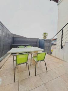 a table and two green chairs on a balcony at Cozy studio Annecy in Poisy