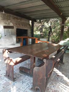 a wooden table and bench on a patio at LO de JIMENA in Los Cardales