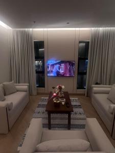 a living room with two couches and a tv at فندق الوعل بالخفجى in Khafji