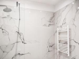 a bathroom with white marble walls and a ladder at DoR Stay Seaside in Durrës +50 photos