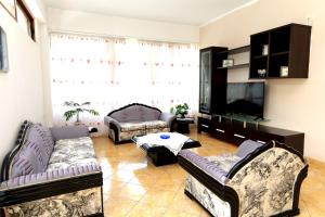 a living room with couches and a flat screen tv at Villa Ekluxe in Delvinë
