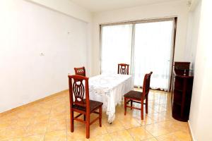 a dining room with a table and four chairs at Villa Ekluxe in Delvinë