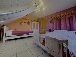 a bedroom with two beds and purple curtains at L'Orée des Bois in Paliseul