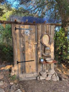 a wooden outhouse with a door and a sink at Nuit insolite et féerique tout près d'Ajaccio in Alata +19 photos