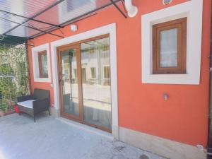 an orange building with a glass door and a bench at La Casa Rossa II in Verona