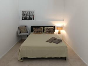 a bedroom with a bed with a lamp and a chair at Funicolare 64 in Paradiso