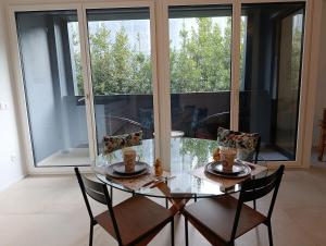 a glass dining room table with chairs and a window at Funicolare 64 in Paradiso +12 photos