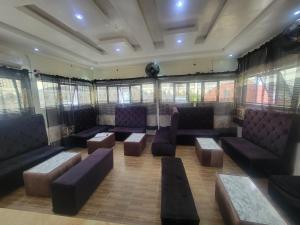 a waiting room with couches and tables and windows at Kings Garden Inn in Ekrokpe