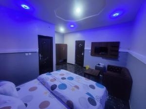 a bedroom with a bed and a couch and a tv at Kings Garden Inn in Ekrokpe