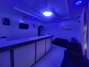 a bar with blue lights and chairs in a room at Kings Garden Inn in Ekrokpe