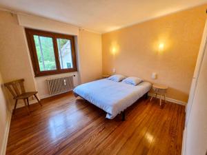a bedroom with a bed and a table and a window at Maison BAVANS in Bavans
