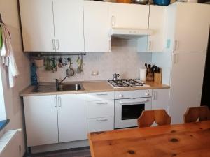 a kitchen with white cabinets and a stove top oven at Casa Camomilla in Creto