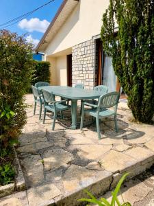 a green table and chairs on a stone patio at Maison BAVANS in Bavans