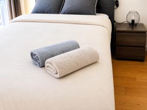 a bed with a towel on the side of it at Chambre moderne au Petit Bayonne chez particulier in Bayonne