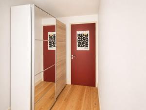 a hallway with a glass door and a red door at Chambre moderne au Petit Bayonne chez particulier in Bayonne