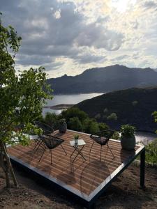 a wooden deck with two chairs and a table at Estrela do Gerês - Casa Fernandes in Outeiro