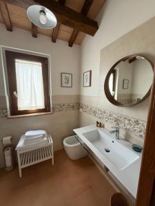 a bathroom with a sink and a toilet and a mirror at Il Casale del Tiglio in Monteleone dʼOrvieto