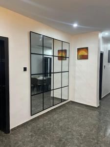 a room with a glass wall with a table in it at Kayus Place in Isaga-Abosule