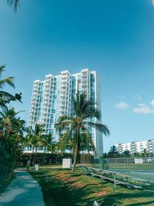 a large building with palm trees in front of it at Blue Diamond Suite de playa in Playa Blanca