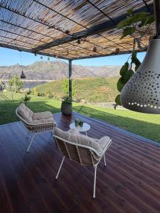 a patio with two chairs and a table on a deck at Estrela do Gerês - Casa Fernandes in Outeiro