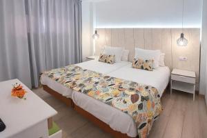 a hotel room with a large bed with pillows at Apartamentos Gelimar in Puerto Rico de Gran Canaria +49 photos