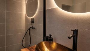 a bathroom with a copper sink and a mirror at Dreiländer Blick Apartment Premium in Lörrach +10 photos
