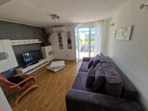 a living room with a couch and a television at Apartman Gizdavac in Gizdavac