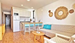 a living room with a couch and a kitchen at Apartamentos Gelimar in Puerto Rico de Gran Canaria
