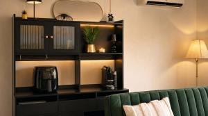 a room with a couch and a shelf with a coffee maker at Dreiländer Blick Apartment Premium in Lörrach