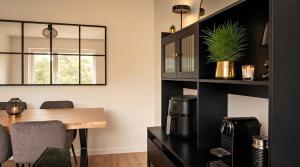 a dining room with a table and a black shelf at Dreiländer Blick Apartment Premium in Lörrach