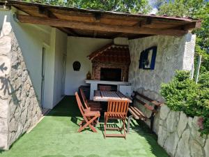 a patio with a table and chairs and a fireplace at Apartman Gizdavac in Gizdavac